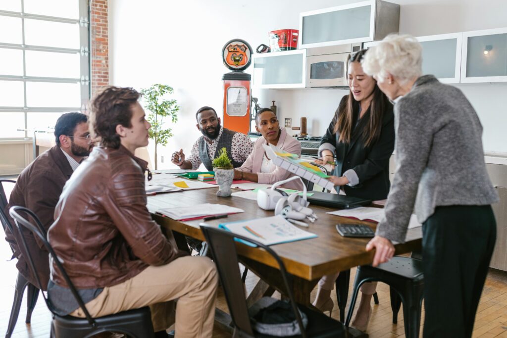 Home Colleagues engaged in a collaborative business meeting around a table in a modern office setting.